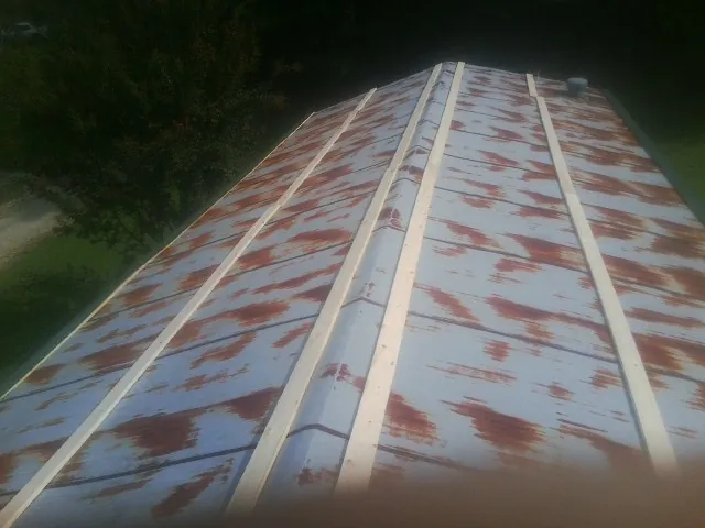 Rusted metal roof panels with new wood purlins before replacement — Storm Damage Roof Repair in Constantine by Roofing Brothers