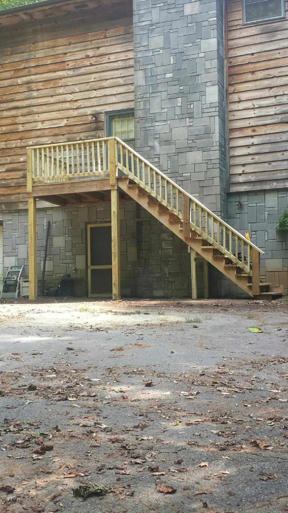 New pressure treated deck and stair landing on a log home in Constantine
