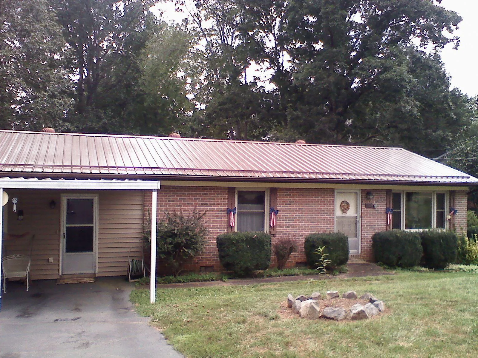 Bronze metal roof and carport on a brick ranch home — Roof Repair work by our crew in Constantine